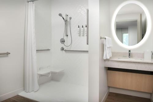 a bathroom with a shower and a sink and a mirror at TownePlace Suites by Marriott Cincinnati Mason in Mason