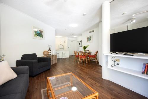 a living room with a couch and a tv at Golden Sands Beachfront Resort in Yorkeys Knob