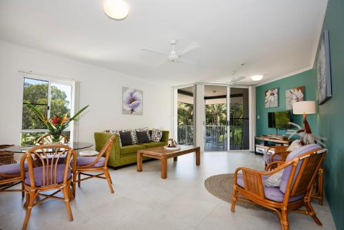 a living room with a couch and a table and chairs at Golden Sands Beachfront Resort in Yorkeys Knob
