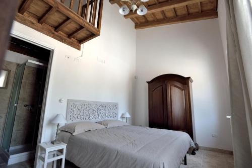Schlafzimmer mit einem großen Bett mit einem Kopfteil aus Holz in der Unterkunft Villa Giorgia in Monopoli
