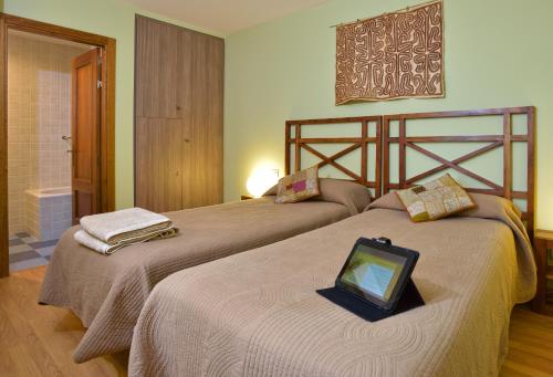 a bedroom with two beds with a tablet on top of them at Ruta del Tiempo in Sos del Rey Católico