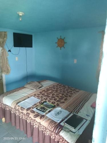 a bedroom with a bed with a tv on the wall at Centro Recreativo Kilómetro 10 in Isla de La Pacanda