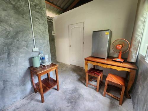 a room with a table with a tv and a stool at lungpeiykhomestay house in Ban Bang Bao