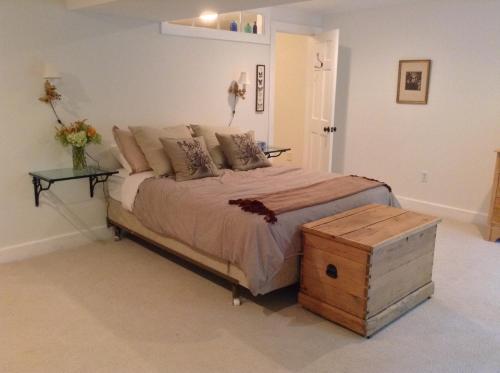 a bedroom with a large bed with a wooden trunk at Haddock Hill House in Old Chatham