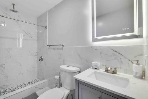 a white bathroom with a toilet and a sink at Cozy, Spacious House *New*InTheCommunity+Fire Pit in Tobyhanna