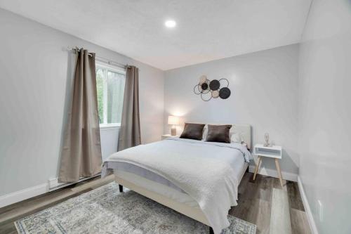 a white bedroom with a bed and a window at Cozy, Spacious House *New*InTheCommunity+Fire Pit in Tobyhanna