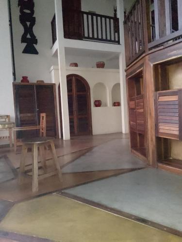 Pokój z drewnianym stołem i drewnianymi drzwiami w obiekcie Satrana beach w mieście Ambaro