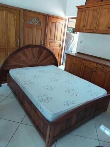 drewnianym łóżkiem w pokoju z drewnianymi szafkami w obiekcie Satrana beach w mieście Ambaro