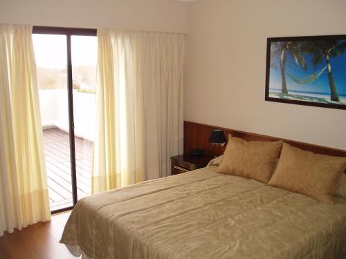 - une chambre avec un lit et une porte coulissante en verre dans l'établissement Hotel MAXIM, à Trinidad