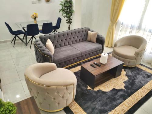 a living room with a couch and chairs and a table at GRAND VILLA DAKAR in Dakar