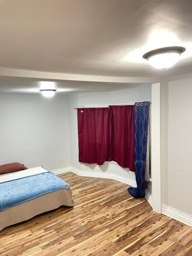 een slaapkamer met een bed en een rood gordijn bij Cozy place to rest in Hamilton