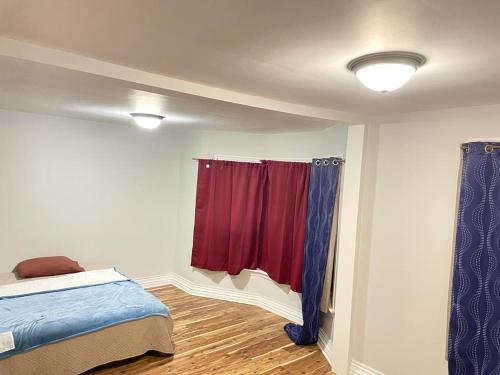 sypialnia z łóżkiem i czerwoną zasłoną w obiekcie Cozy place to rest w mieście Hamilton