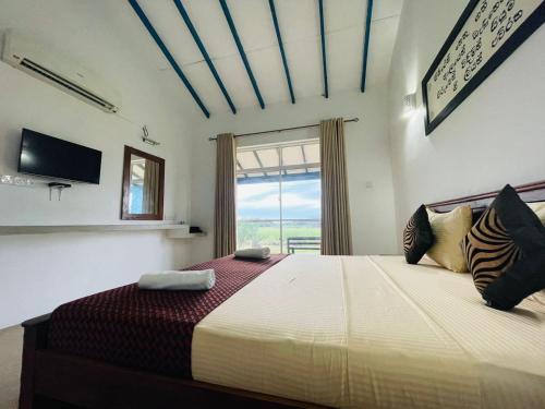 a bedroom with a large bed with a window at RHO Sigiriya Lake Edge Retreat & Spa in Sigiriya