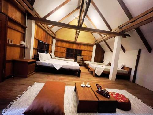 a large room with two beds and a table at Devi Kampot Resort at Phum Kampot in Kampot