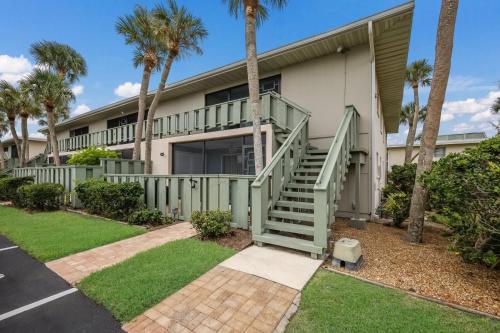 a house with palm trees in front of it at West Bay Cove 218 condo in Holmes Beach