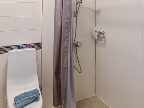 a shower with a glass door next to a toilet at Beach Bungalow in Belton