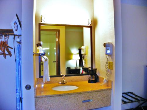 La salle de bains est pourvue d'un lavabo et d'un grand miroir. dans l'établissement Royalton Inn & Suites Upper Sandusky, à Upper Sandusky