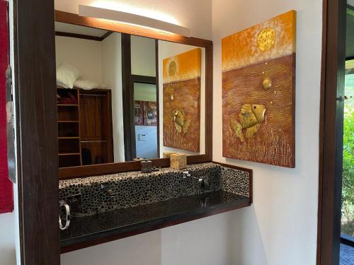 W łazience znajduje się lustro i umywalka. w obiekcie Private Island Experience w mieście Vitouara