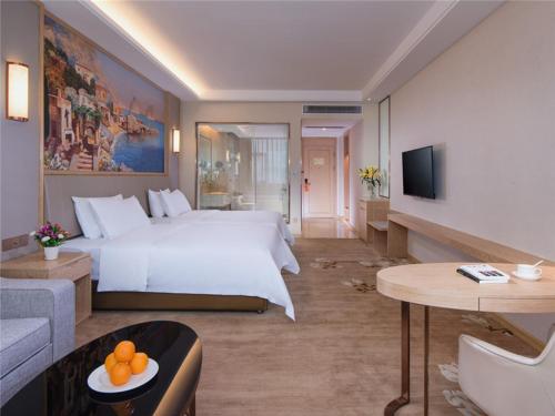 Habitación de hotel con cama grande y sofá en Vienna International Hotel (Lianjiang Avenue Xinyuan International Plaza), en Lianjiang