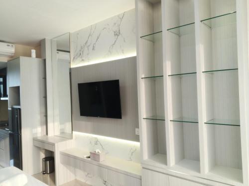 a bathroom with glass shelves and a television on the wall at MESA Thamrin City Apartments at Nagoya with Netflix & Pick Up Service in Nagoya