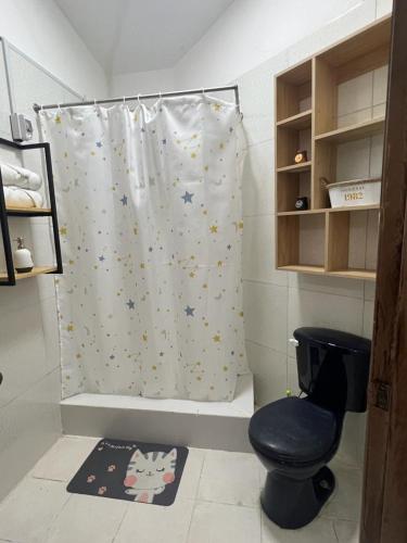 a bathroom with a shower curtain and a toilet at Departamento Horizonte in Manta