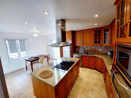 a kitchen with wooden cabinets and a counter top at La Finca de Ananás - House in Ponta Delgada
