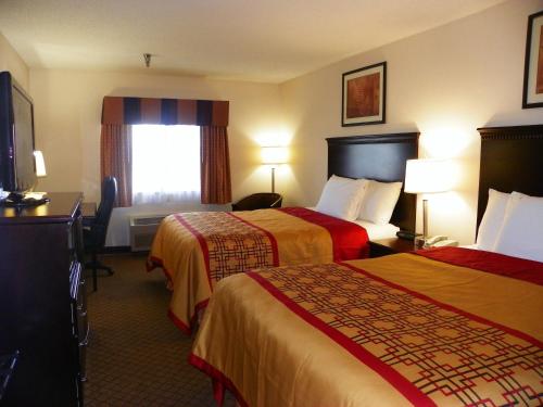 Cette chambre comprend deux lits et une télévision. dans l'établissement Royalton Inn & Suites Upper Sandusky, à Upper Sandusky