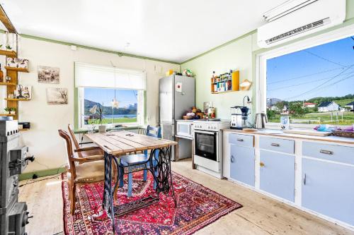 a kitchen with a wooden table and a table at Storjord Farmstay Ranchhouse in Kvaløya