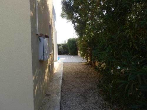 an empty alley with a white building and trees at Villa Elina in Paphos City