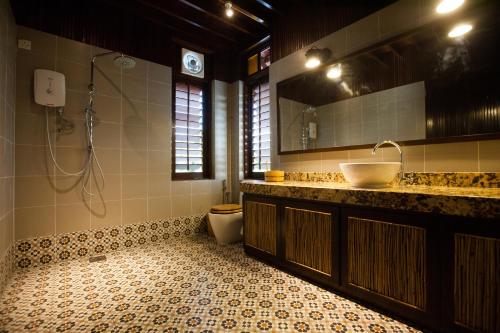 a bathroom with a sink and a toilet at Arundina in Ipoh