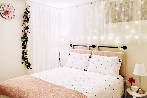a bedroom with a bed and a clock on the wall at Private Studio Suite with Full Bath - Parking - 15 mins to Downtown in Vancouver