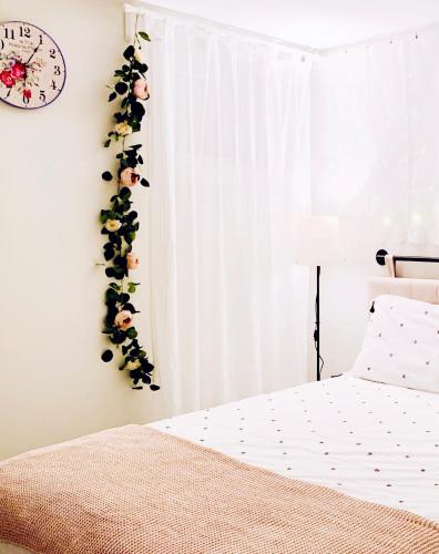 a bedroom with a flower garland on the wall at Private Studio Suite with Full Bath - Parking - 15 mins to Downtown in Vancouver