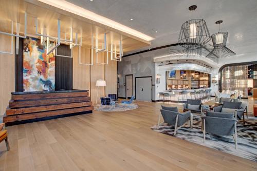 a large lobby with chairs and a table at The Farnam, Autograph Collection in Omaha