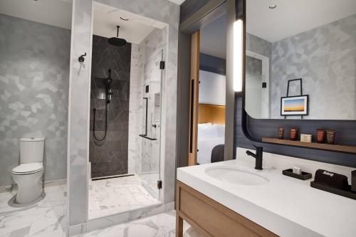 a bathroom with a sink and a shower and a toilet at The Farnam, Autograph Collection in Omaha