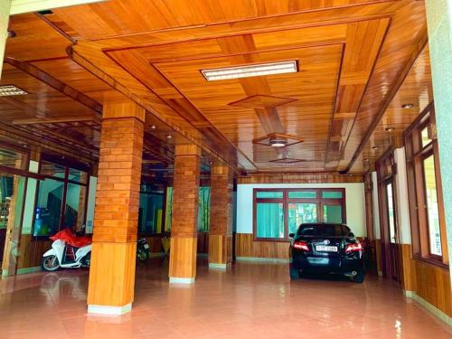 MẠNH LÊ GIA HOTEL في Plei Brel (2): سيارة متوقفة في غرفة كبيرة بسقوف خشبية