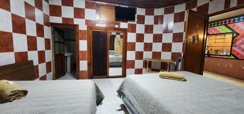 a bedroom with two beds and a checkered wall at Hostal Choja in Quetzaltenango