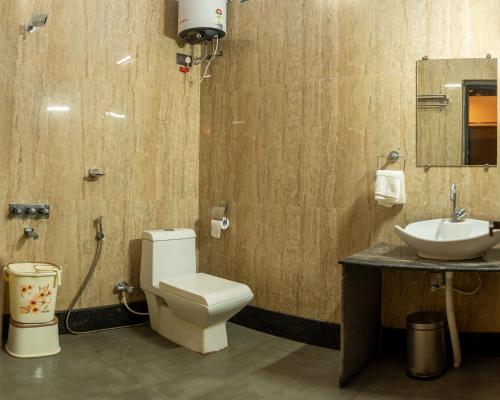 a bathroom with a toilet and a sink at Mastiff Select Shreeyog Resort in Dandeli