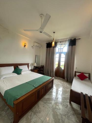 a bedroom with two beds and a ceiling fan at Arcadia House Hanthana in Kandy