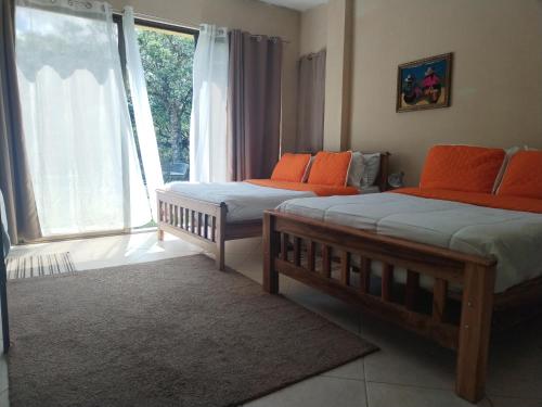 two beds in a room with a large window at Campestre House in Alto Boquete