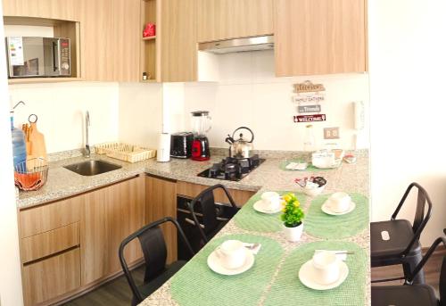 Una cocina con una mesa con sillas y una encimera. en Open House Apart Centro Iquique, en Iquique