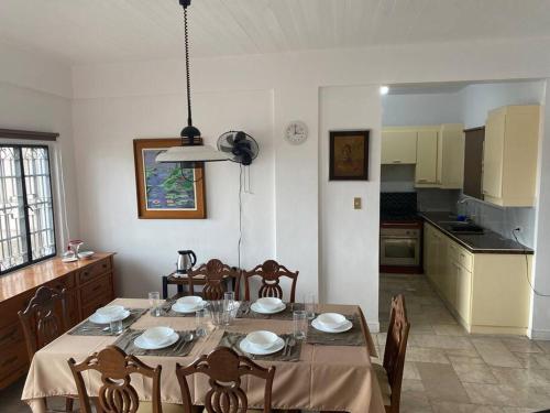ein Esszimmer mit einem Tisch und Stühlen sowie eine Küche in der Unterkunft Burgitos Homescape Tagaytay in Tagaytay