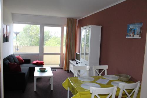 un soggiorno con tavolo, sedie e una finestra di Ferienwohnung E511 für 2-4 Personen an der Ostsee a Brasilien (Schönberg)