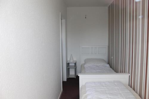 a small bedroom with two beds and a night stand at Ferienwohnung E511 für 2-4 Personen an der Ostsee in Brasilien