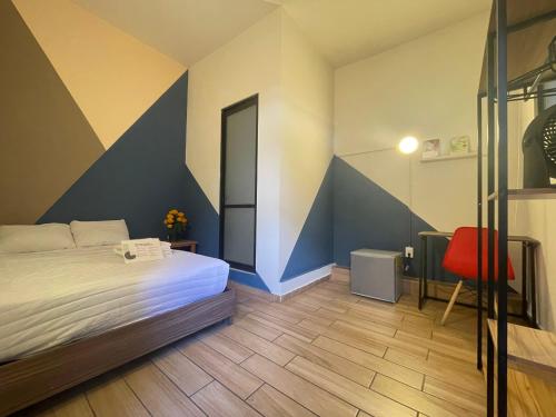 - une chambre avec un lit et une chaise rouge dans l'établissement Colmena Tonala, à Mexico