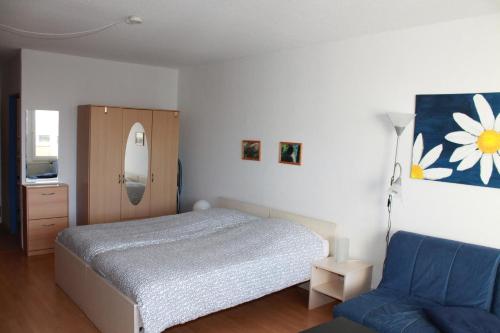 ein Schlafzimmer mit einem Bett und einem blauen Stuhl in der Unterkunft Ferienappartement K110 für 2-4 Personen in Strandnähe in Brasilien
