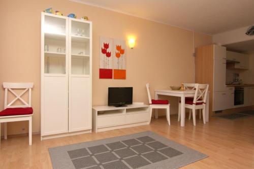 a living room with a television and a table with chairs at Ferienwohnung K013 für 2-4 Personen an der Ostsee in Brasilien