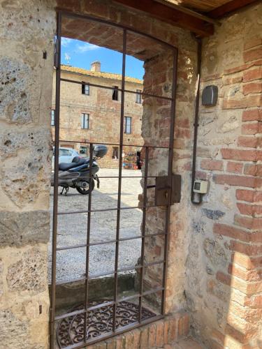 an open door in a brick wall with a window at Monteriggioni Castello in Monteriggioni