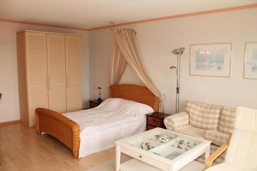 ein Schlafzimmer mit einem Bett, einem Sofa und einem Tisch in der Unterkunft Ferienapartment K1003 mit Ostseeblick in Brasilien