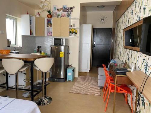 a kitchen with a refrigerator and a table with chairs at Wanderer's Trove in Davao City