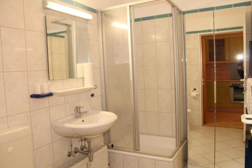 ein Bad mit einem Waschbecken und einer Dusche in der Unterkunft Ferienapartment K1003 mit Ostseeblick in Brasilien